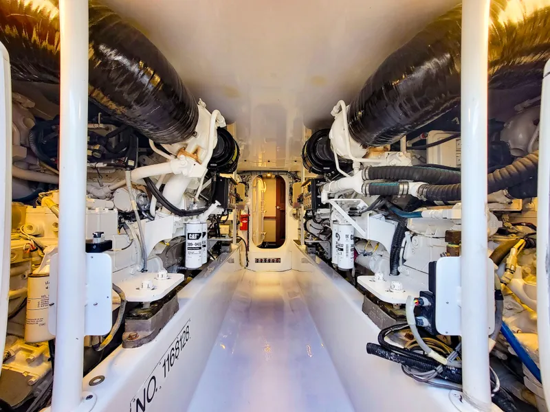 Slide: The Image of Engine room of 2005 Custom Carolina 66 yacht, showcasing dual engines and mechanical components. - 44