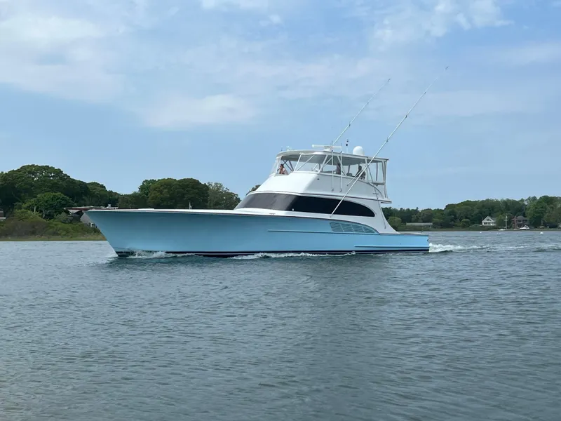 Slide: The Image of 2005 Custom Carolina 66 yacht cruising on a calm waterway under a clear sky. - 45
