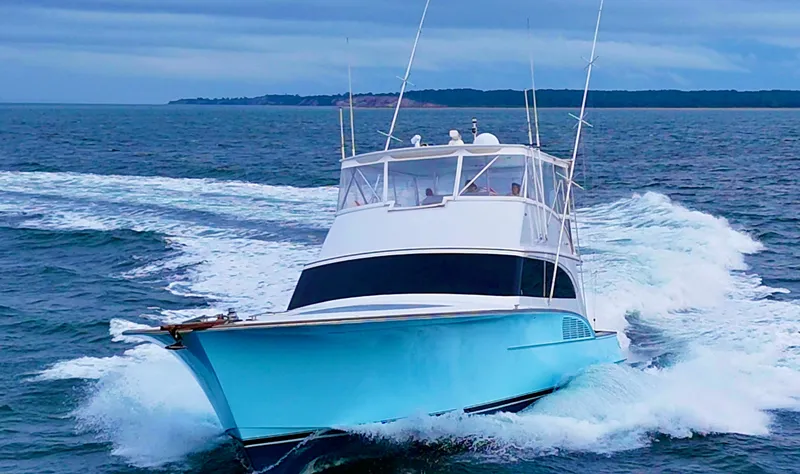 Slide: The Image of 2005 Custom Carolina 66 yacht cruising on open water, showcasing sleek design and powerful performance. - 48