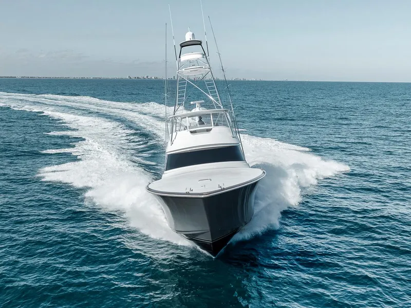 Slide: The Image of 2023 Viking 72 Convertible yacht cruising swiftly on open ocean waters. - 15
