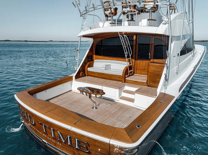 Slide: The Image of 2023 Viking 72 Convertible yacht on water, featuring spacious deck and elegant wood finish. - 18
