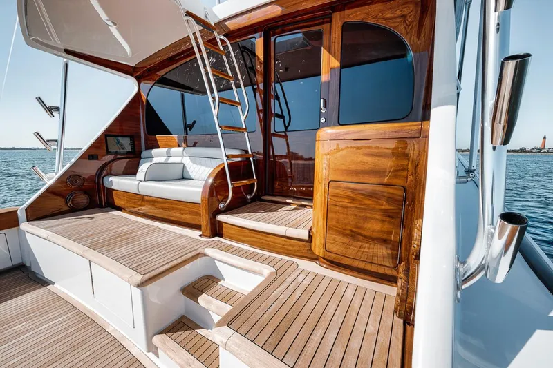 Slide: The Image of 2023 Viking 72 Convertible yacht with elegant wooden deck and seating area. - 22