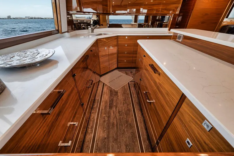 Slide: The Image of Luxurious kitchen interior of 2023 Viking 72 Convertible yacht with wooden cabinetry and ocean view. - 31