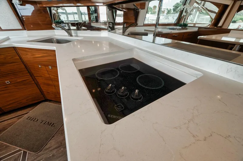 Slide: The Image of Modern kitchen in 2023 Viking 72 Convertible yacht with sleek countertops and stove. - 34