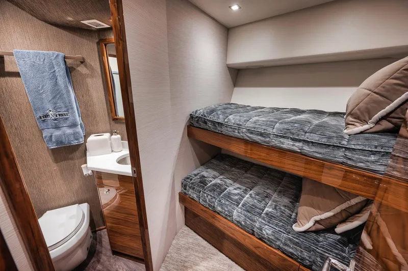 Slide: The Image of 2023 Viking 72 Convertible yacht interior with bunk beds and bathroom. - 47
