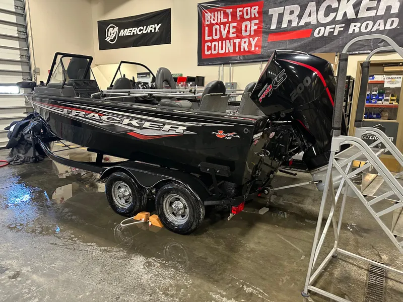 Slide: The Image of 2023 Tracker Targa V-18 WT boat in showroom, featuring Mercury engine and promotional banners. - 5