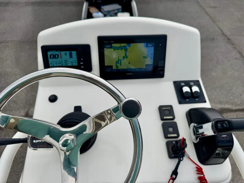 Slide: The Image of 2019 Pathfinder 2600 HPS boat dashboard with steering wheel and navigation screens. - 13