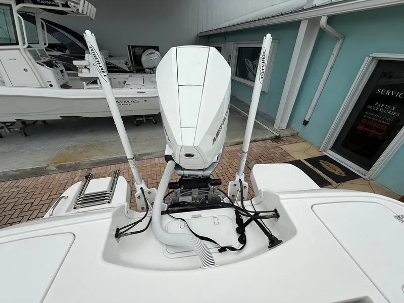 Slide: The Image of 2021 Caymas 26 HB boat engine and deck view in a showroom setting. - 11