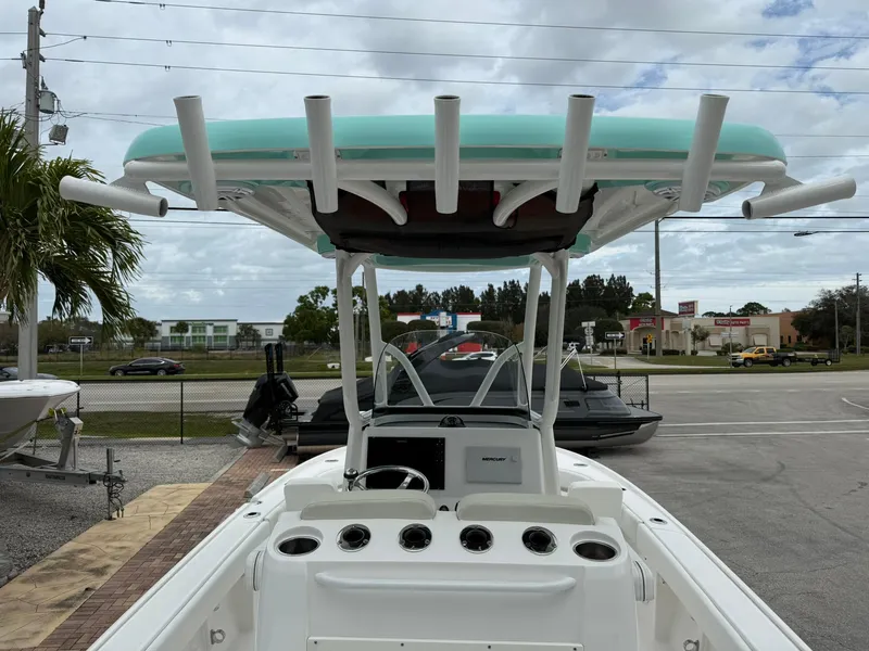 Slide: The Image of 2021 Caymas 26 HB boat, rear view, docked, with T-top and rod holders. - 16