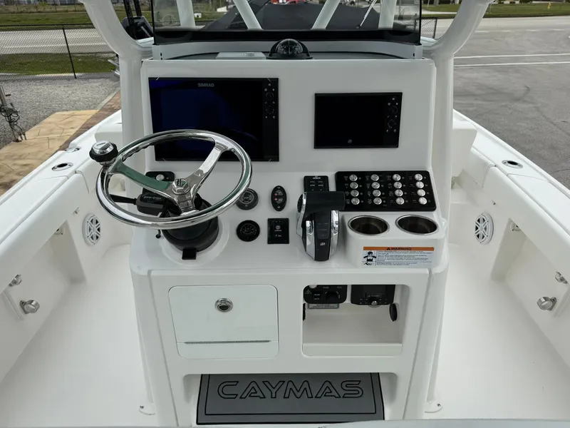 Slide: The Image of 2021 Caymas 26 HB boat console with steering wheel, controls, and electronic displays. - 20