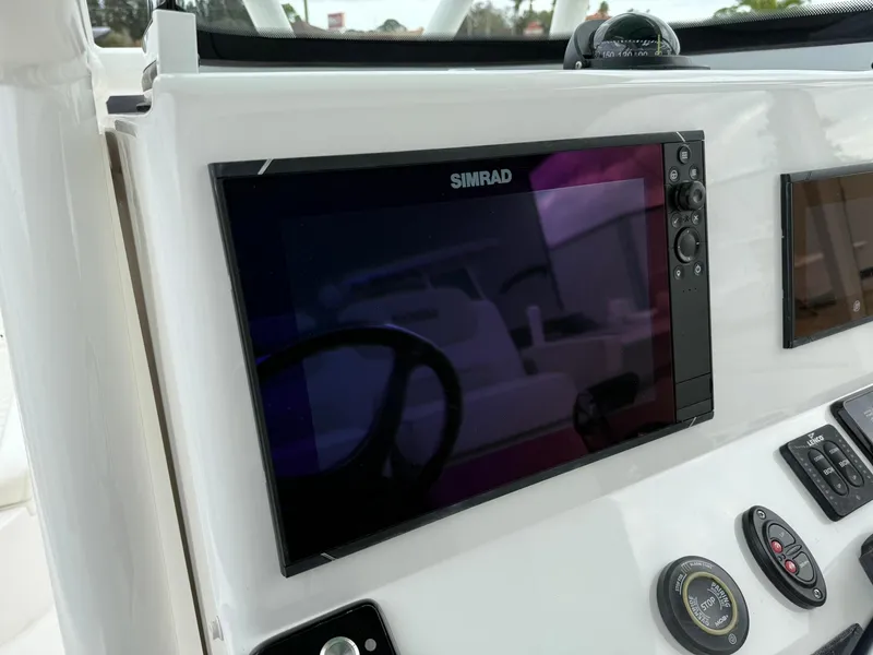 Slide: The Image of Simrad display on 2021 Caymas 26 HB boat dashboard, featuring navigation controls. - 22