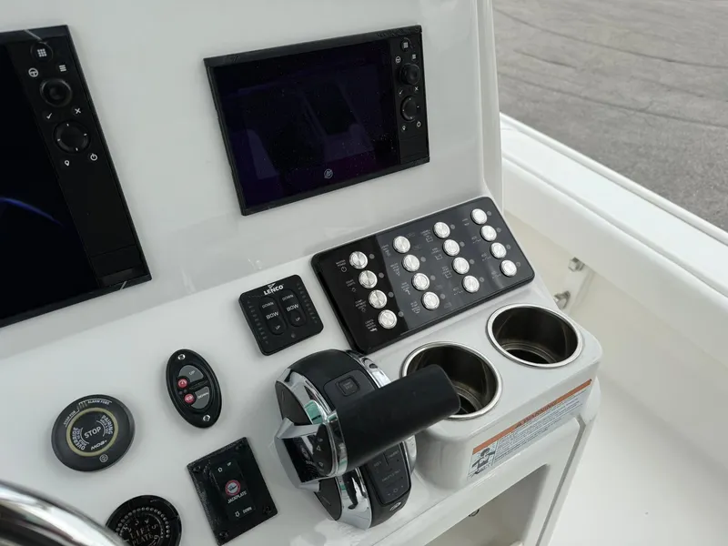 Slide: The Image of Control panel of 2021 Caymas 26 HB boat with navigation screens and cup holders. - 23
