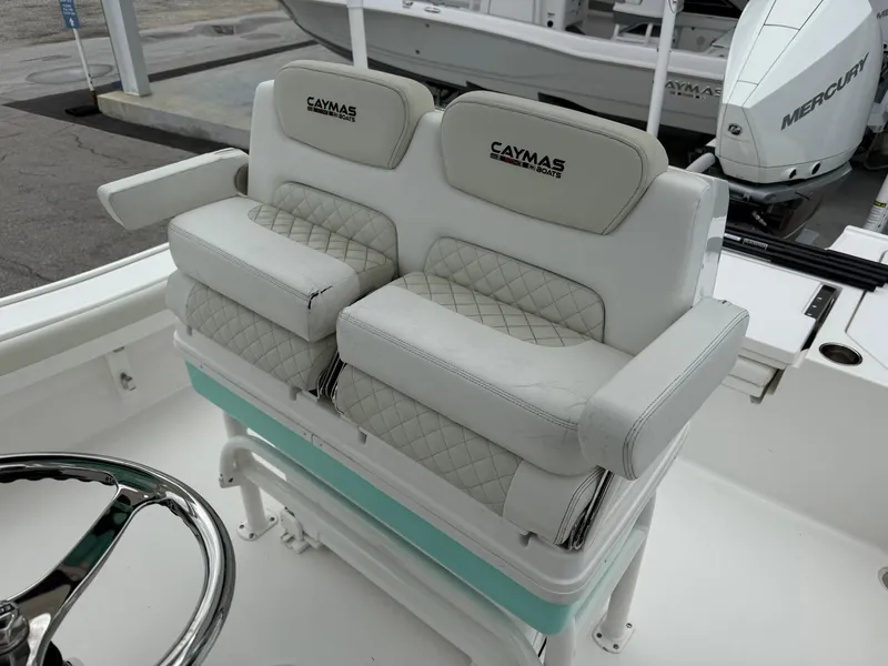 Slide: The Image of 2021 Caymas 26 HB boat with cushioned seating and steering wheel. - 25