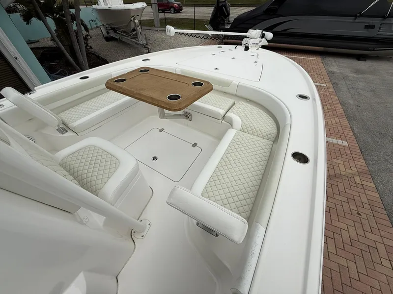 Slide: The Image of 2021 Caymas 26 HB boat interior with cushioned seating and wooden table. - 29
