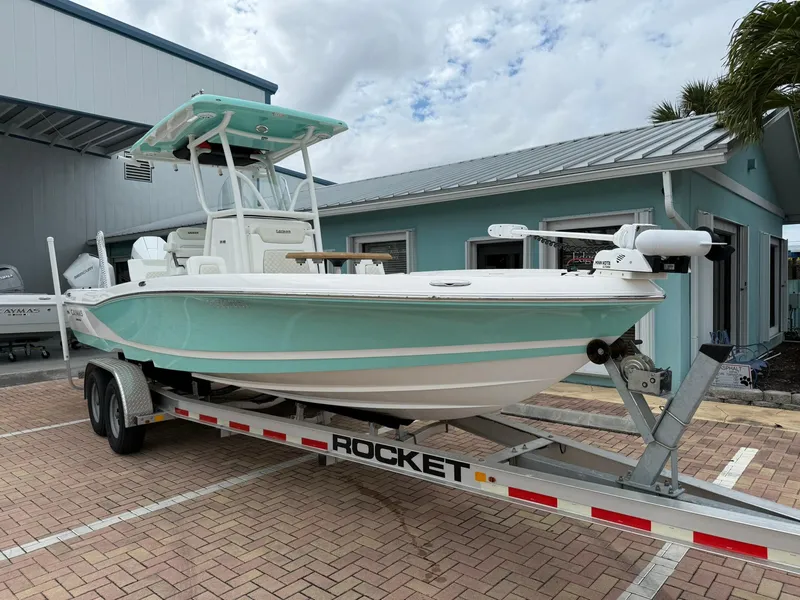 Slide: The Image of 2021 Caymas 26 HB boat on trailer, parked outside a building. - 3