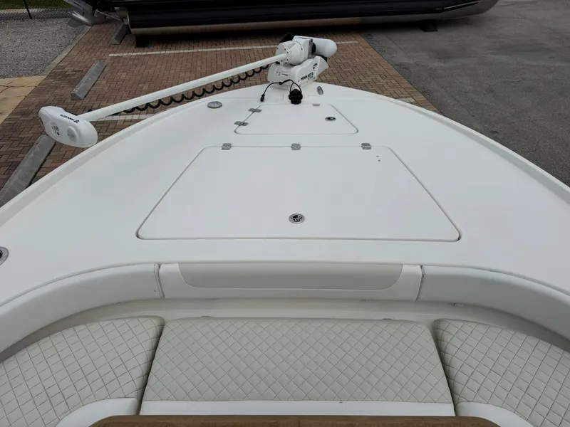 Slide: The Image of 2021 Caymas 26 HB boat deck with trolling motor, featuring white cushioned seating. - 32