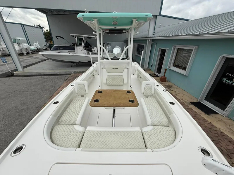 Slide: The Image of 2021 Caymas 26 HB boat with spacious seating and center console, docked near a building. - 34