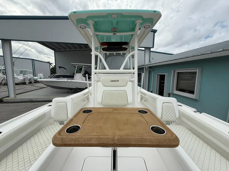 Slide: The Image of 2021 Caymas 26 HB boat interior with table and seating, docked at a marina. - 36