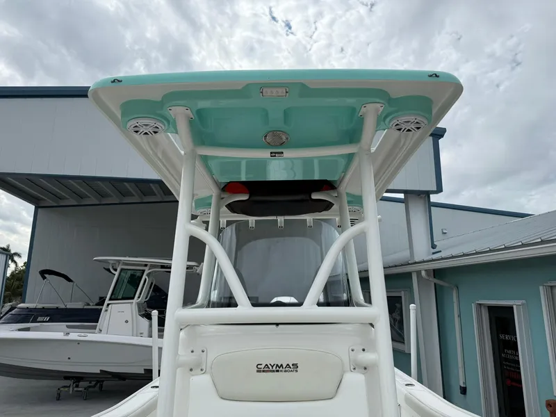 Slide: The Image of 2021 Caymas 26 HB boat with teal canopy, docked at a marina under cloudy skies. - 37