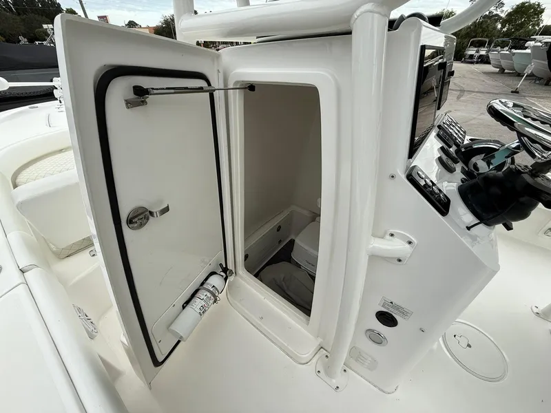 Slide: The Image of 2021 Caymas 26 HB boat console storage with open door and visible fire extinguisher. - 39