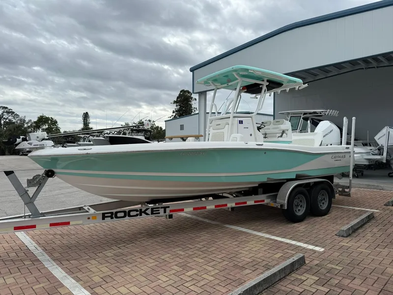 Slide: The Image of 2021 Caymas 26 HB boat on trailer, parked outdoors near a building. - 6