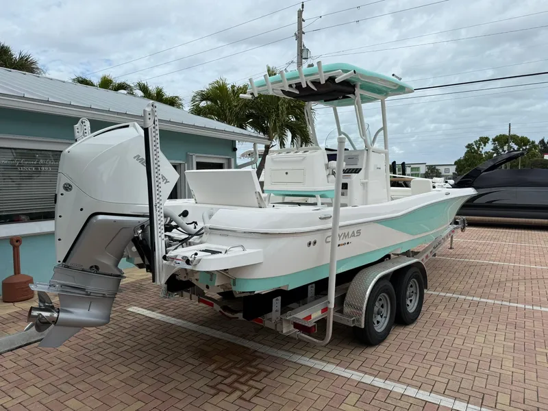 Slide: The Image of 2021 Caymas 26 HB boat on trailer, parked outdoors, featuring a powerful outboard motor. - 9