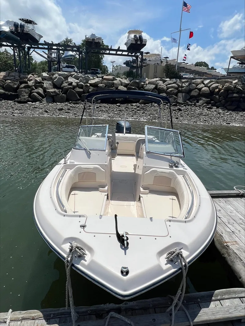 Slide: The Image of 2010 Grady-White Tournament 225 boat docked by rocky shoreline under a clear sky. - 3