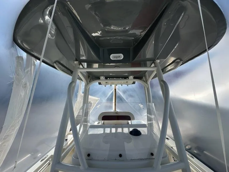 Slide: The Image of 2023 Cobia 220 Center Console boat interior with T-top and console view. - 12