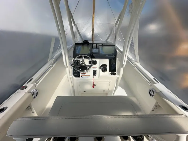 Slide: The Image of 2023 Cobia 220 Center Console boat interior with steering wheel and navigation equipment. - 15