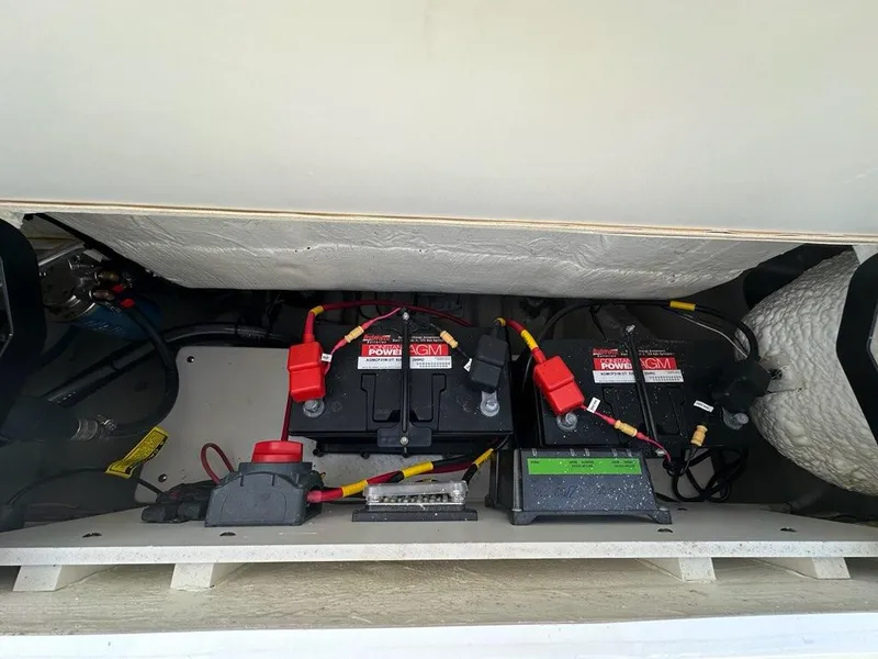 Slide: The Image of 2023 Cobia 220 Center Console boat battery compartment with wiring and components. - 16