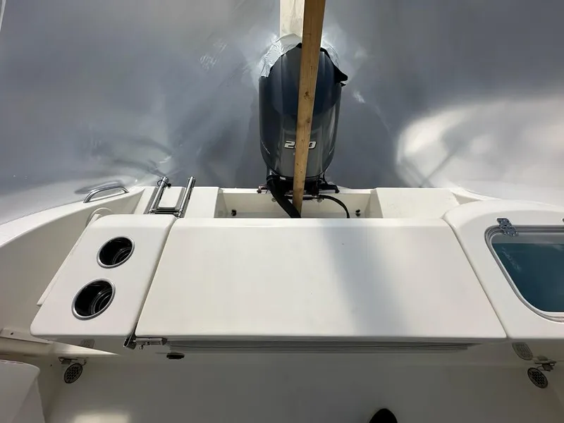 Slide: The Image of 2023 Cobia 220 Center Console boat interior with motor and seating area. - 18