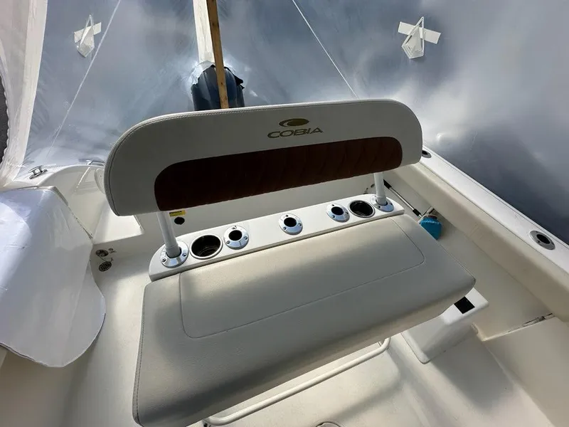 Slide: The Image of 2023 Cobia 220 Center Console boat seat with rod holders and logo. - 19