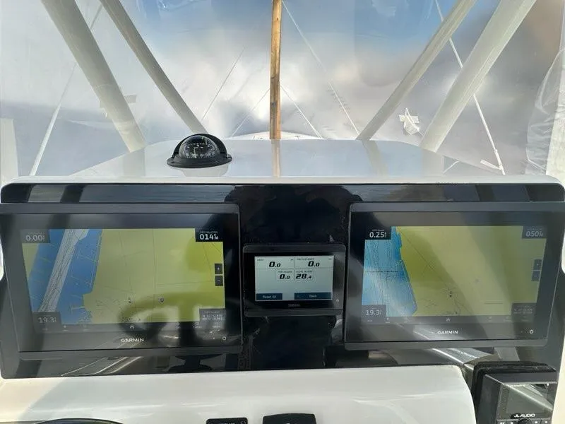 Slide: The Image of 2023 Cobia 220 Center Console dashboard with dual Garmin displays and compass. - 3