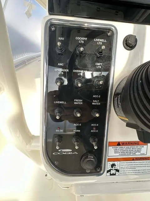 Slide: The Image of Control panel of 2023 Cobia 220 Center Console boat with labeled switches and warnings. - 6