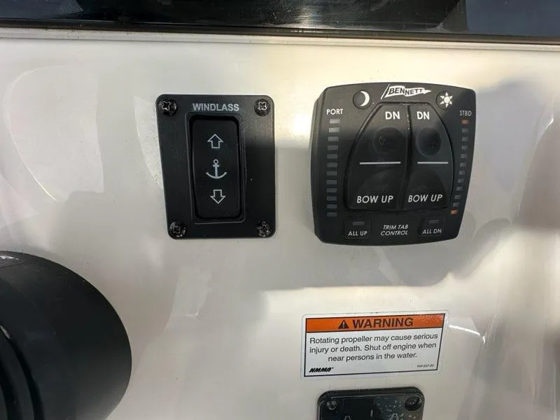 Slide: The Image of Control panel of 2023 Cobia 220 Center Console boat with windlass and trim tab switches. - 7