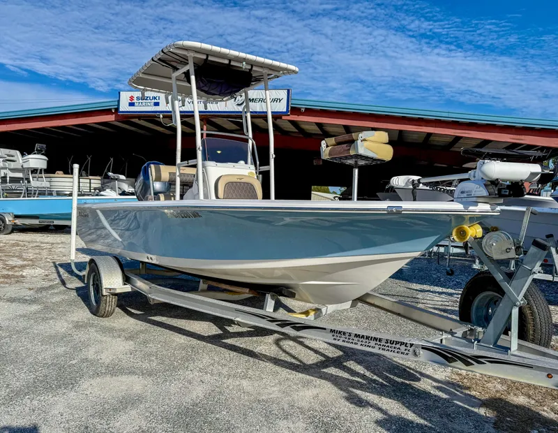 Slide: The Image of 2018 Tidewater 1910 Bay Max boat on trailer, parked outdoors under blue sky. - 11