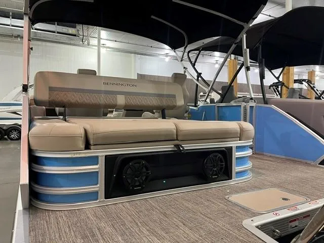 Slide: The Image of 2025 Bennington M22 Swingback pontoon boat with beige seating and blue accents. - 1