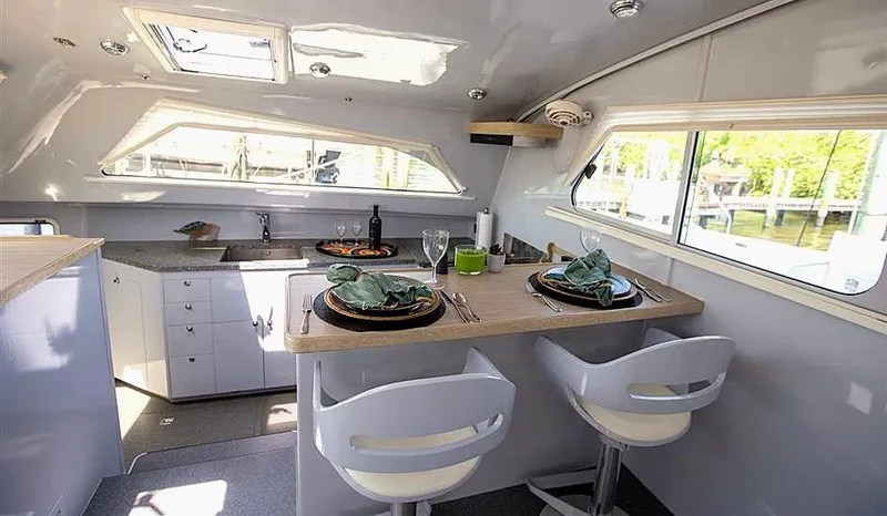 Slide: The Image of Modern yacht interior with dining area, featuring elegant table settings and sleek design. Chris White Atlantic 49. - 10