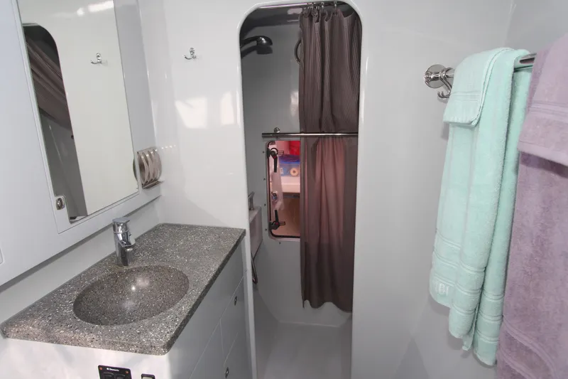 Slide: The Image of Modern yacht bathroom with granite sink, shower, and towels; Chris White Atlantic 49 MastFoil 2018. - 16