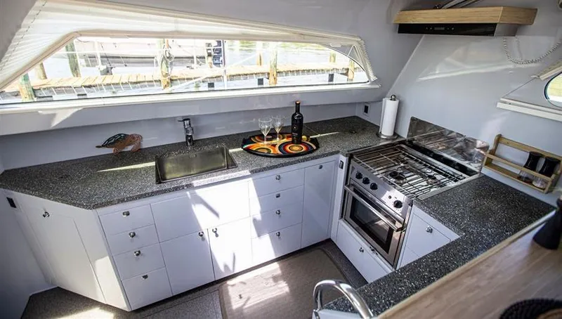 Slide: The Image of Modern yacht kitchen with sleek countertops, stove, and sink in a 2018 Chris White Atlantic 49 MastFoil. - 9