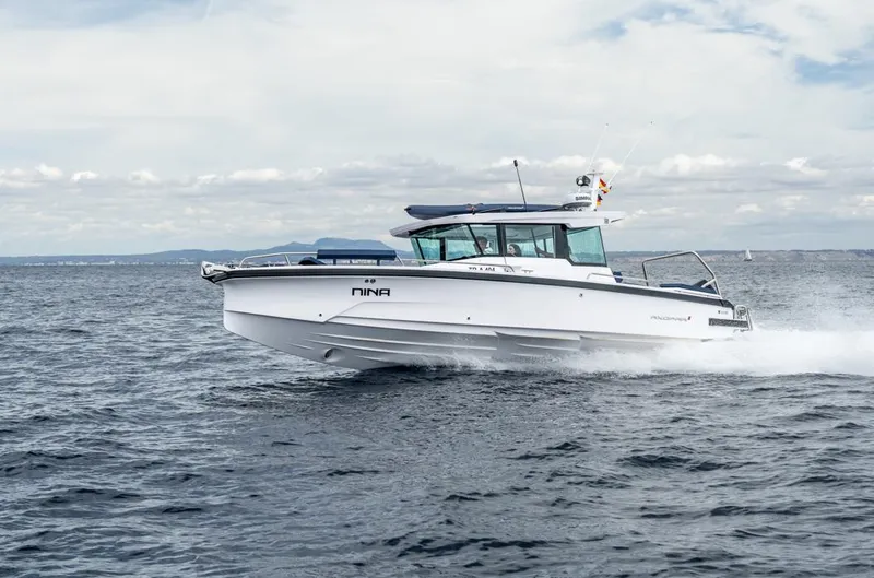 Slide: The Image of 2025 Axopar 29 XC Cross Cabin boat cruising on open water. - 0