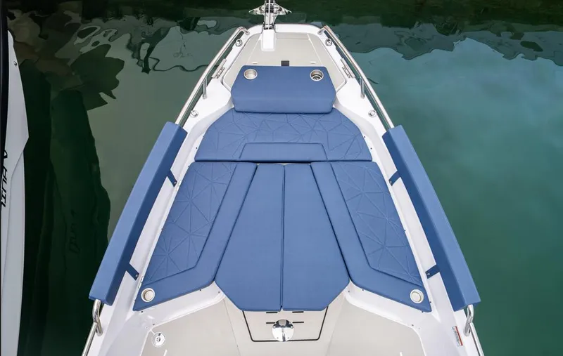 Slide: The Image of 2025 Axopar 29 XC Cross Cabin boat with blue cushioned seating on deck. - 10