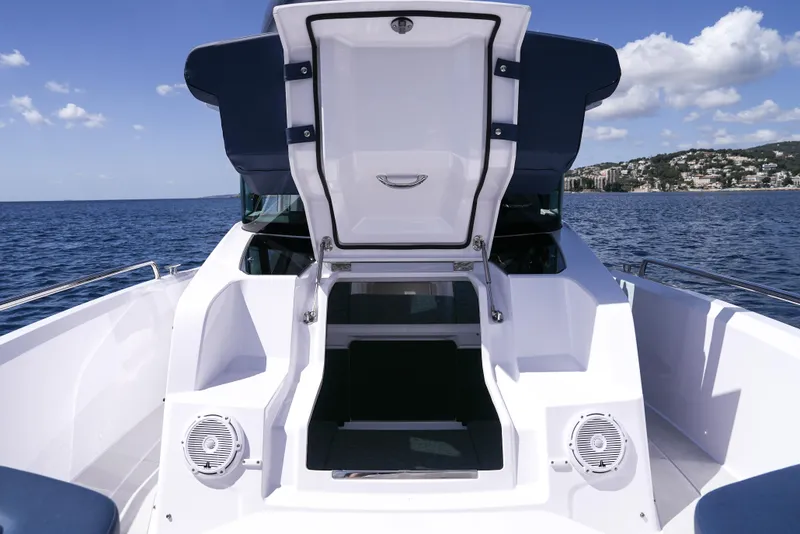 Slide: The Image of 2025 Axopar 29 XC Cross Cabin boat with open hatch, on calm sea. - 18