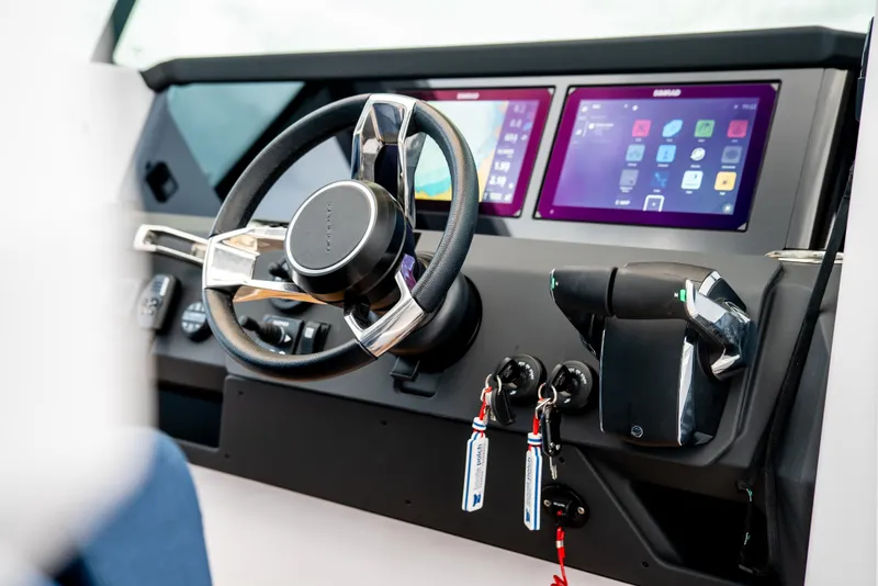 Slide: The Image of 2025 Axopar 29 XC Cross Cabin dashboard with modern steering and dual digital displays. - 5