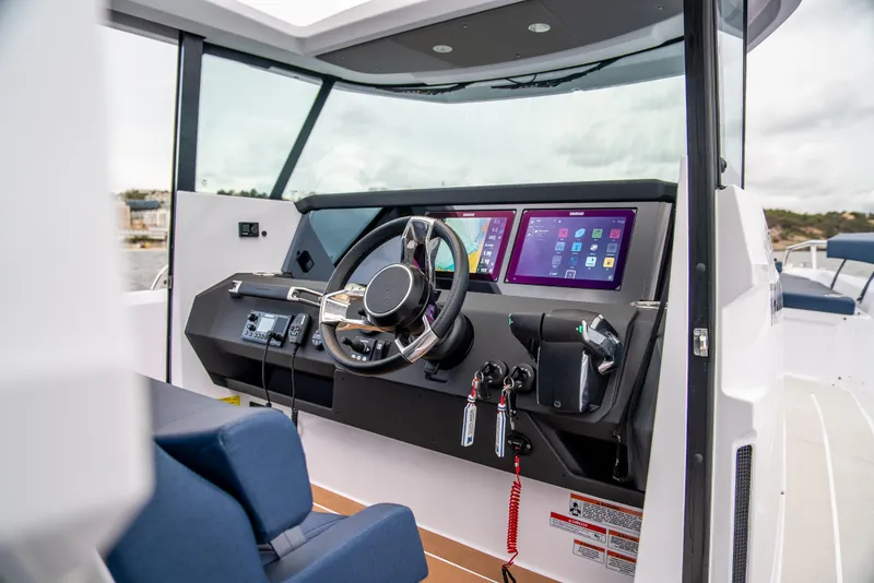 Slide: The Image of 2025 Axopar 29 XC Cross Cabin interior with modern dashboard and steering wheel. - 7