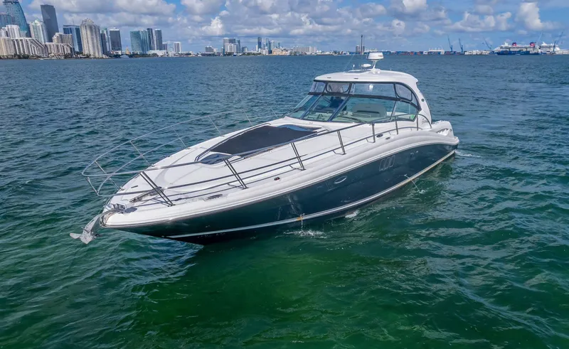 Slide: The Image of 2007 Sea Ray 44 Sundancer yacht cruising in a city harbor under a partly cloudy sky. - 2