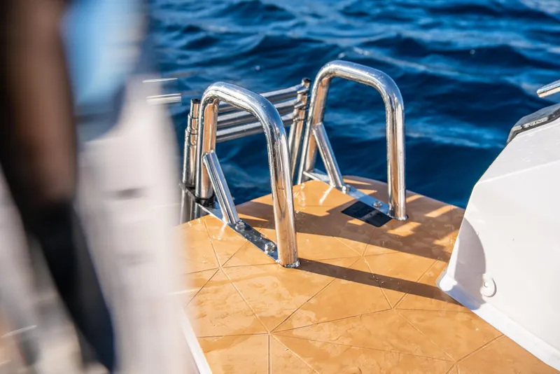 Slide: The Image of 2025 Axopar 29 XC Cross Cabin boat ladder with ocean backdrop. - 15