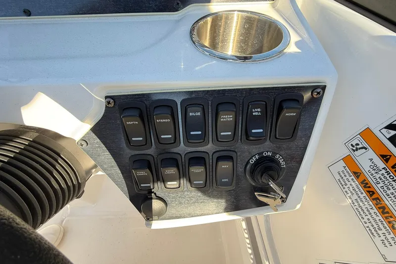 Slide: The Image of Control panel of 2025 Hurricane SunDeck 235 OB boat with switches and ignition key. - 9