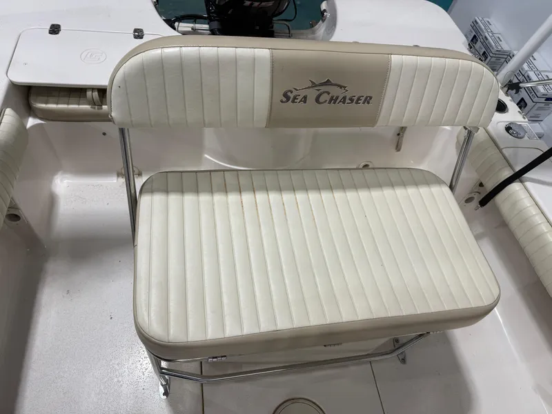 Slide: The Image of 2019 Carolina Skiff 19 Sea Chaser boat seat with "Sea Chaser" logo, white upholstery. - 15