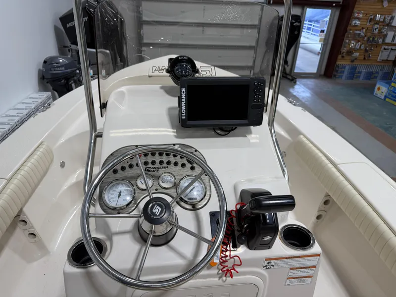 Slide: The Image of 2019 Carolina Skiff 19 Sea Chaser dashboard with steering wheel and navigation equipment. - 20
